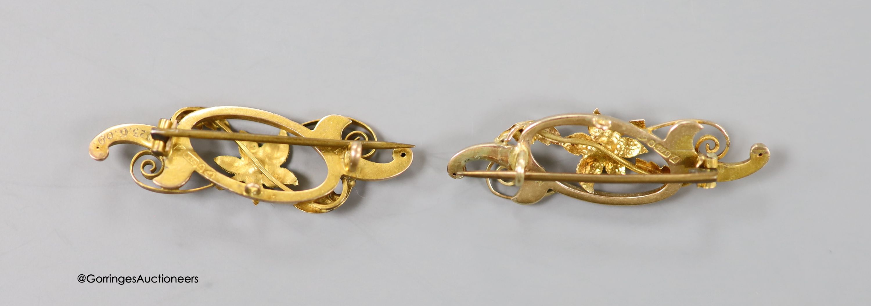 A pair of Edwardian 9ct and gem set open work scroll brooches, 38mm, gross 4 grams.